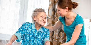 Smiling caregiver helping older woman