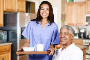 Health care worker helping an elderly man