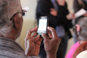 An older African American man using a cell phone