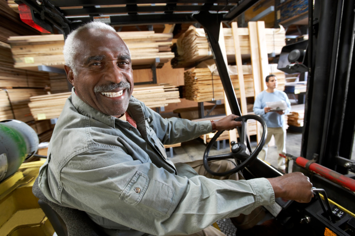 Mature Forklift Driver in Lumber Warehouse