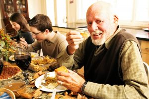 Smiling older man having dinner with his family